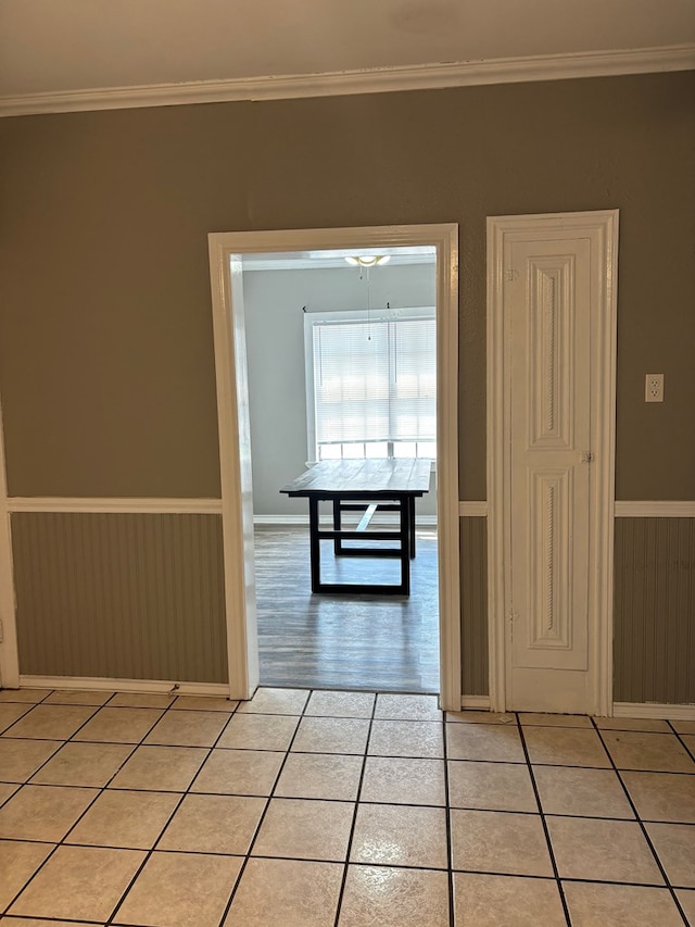 hall featuring crown molding and light tile patterned floors