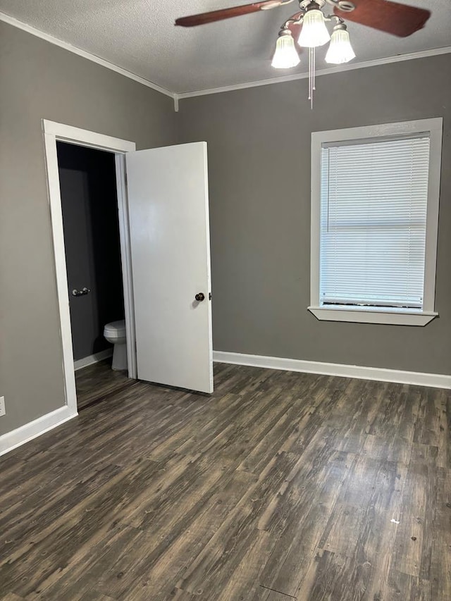 unfurnished bedroom with crown molding, dark wood-type flooring, and a textured ceiling