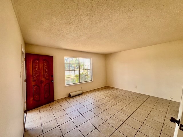 721 Spaulding St, San Angelo, TX 76903 - empty room featuring a textured ceiling and light tile patterned flooring