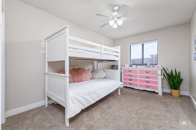 carpeted bedroom featuring ceiling fan and a textured ceiling