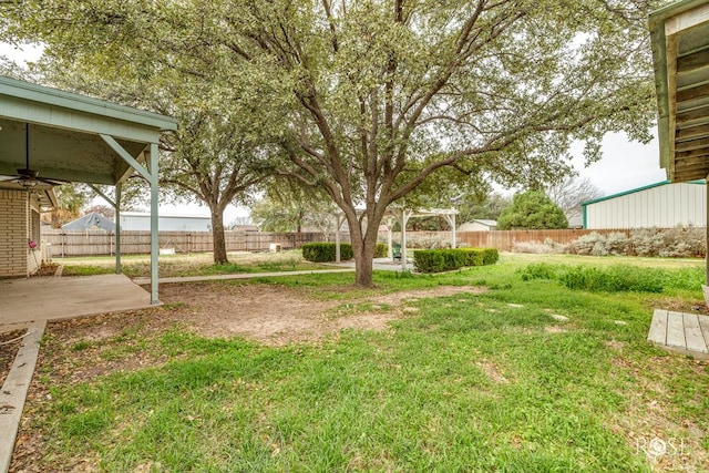 view of yard with a patio area, a fenced backyard, and ceiling fan