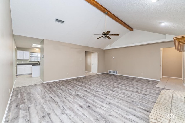 unfurnished living room featuring light wood-type flooring, visible vents, and lofted ceiling with beams