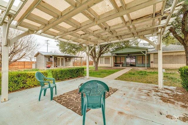 view of patio featuring an outdoor structure and fence