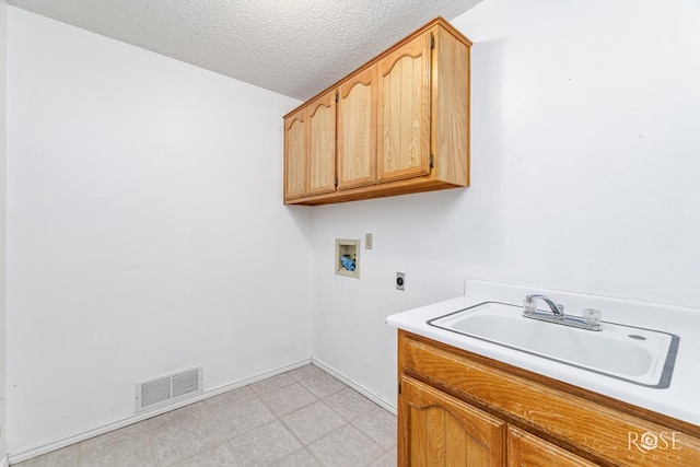 laundry room with visible vents, hookup for a washing machine, a textured ceiling, hookup for an electric dryer, and a sink