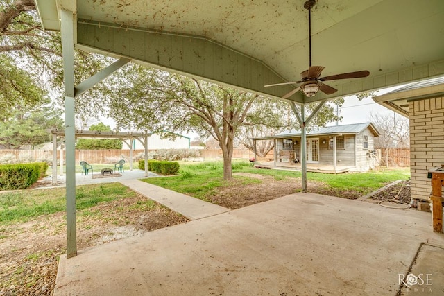 view of patio with an outbuilding, a fenced backyard, and ceiling fan