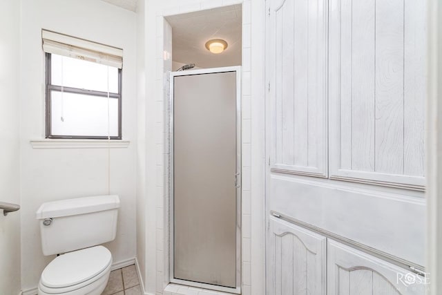 full bath featuring a stall shower, toilet, and tile patterned floors