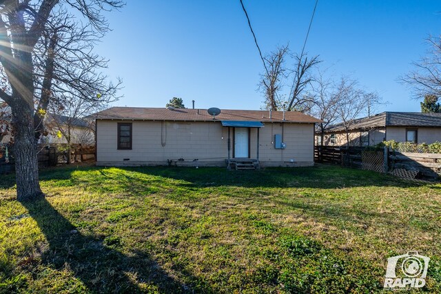 back of property featuring a lawn