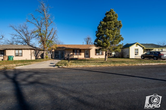 ranch-style home with a garage and a front yard