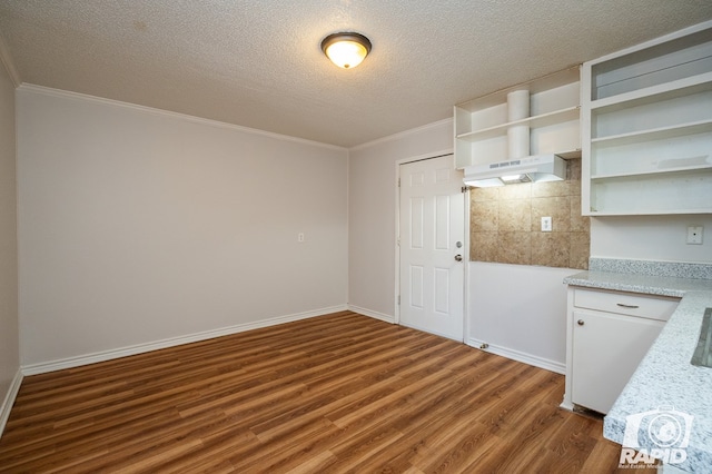 kitchen featuring dark hardwood / wood-style flooring, a textured ceiling, ornamental molding, and white cabinets