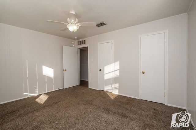 unfurnished bedroom featuring dark colored carpet and ceiling fan