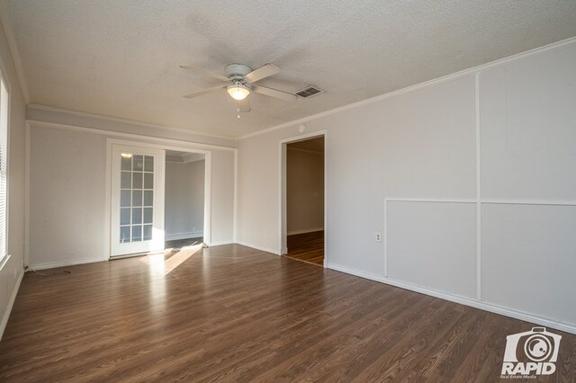 spare room featuring ornamental molding, dark wood-type flooring, a textured ceiling, and ceiling fan