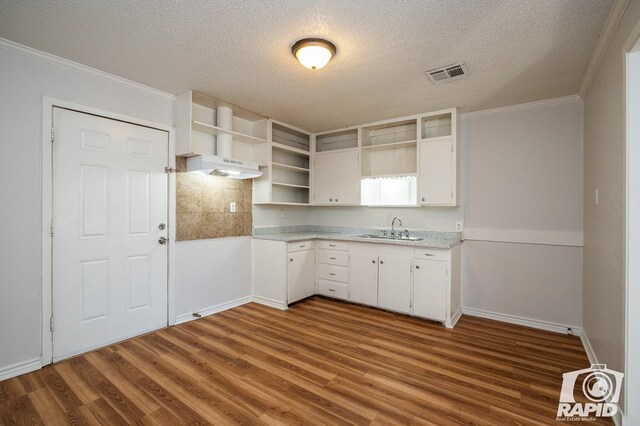 kitchen featuring sink, ornamental molding, a textured ceiling, white cabinets, and dark hardwood / wood-style flooring