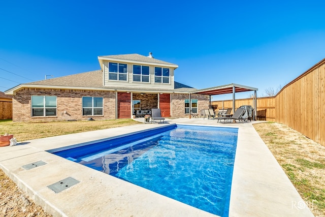 rear view of property with a fenced in pool, a gazebo, and a patio area