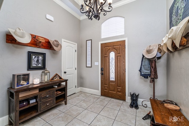 entryway with a high ceiling, crown molding, light tile patterned flooring, and a notable chandelier