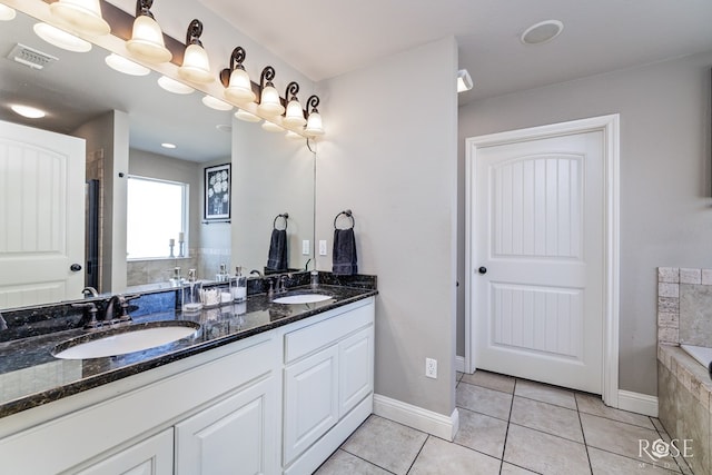 bathroom with tile patterned floors, tiled bath, and vanity