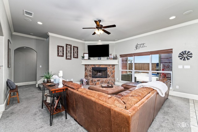 living room featuring crown molding, light tile patterned floors, a stone fireplace, and ceiling fan