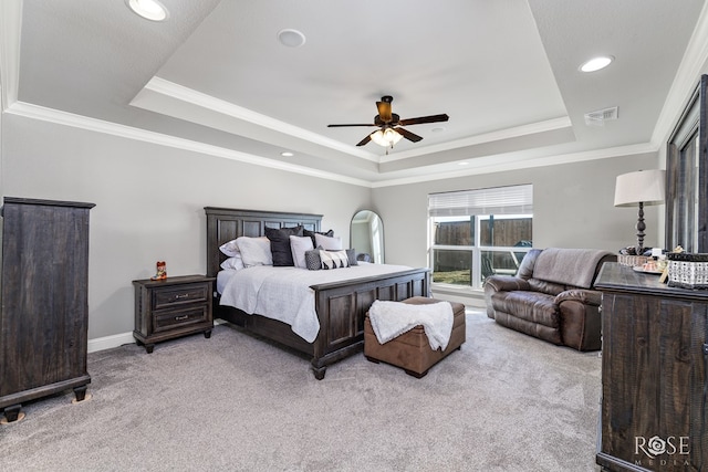 carpeted bedroom with a raised ceiling, ornamental molding, and ceiling fan