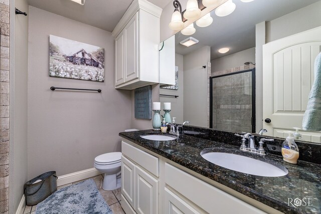 bathroom with tile patterned flooring, toilet, vanity, and a shower with shower door