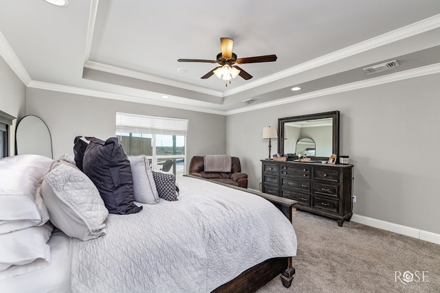 bedroom with ceiling fan, ornamental molding, a tray ceiling, and light colored carpet