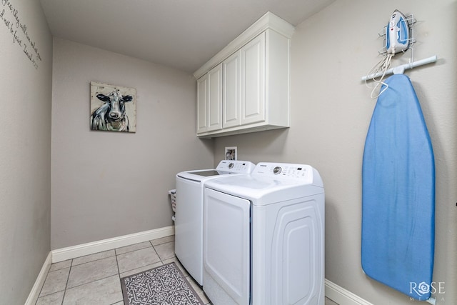 washroom featuring light tile patterned floors, cabinets, and washer and dryer