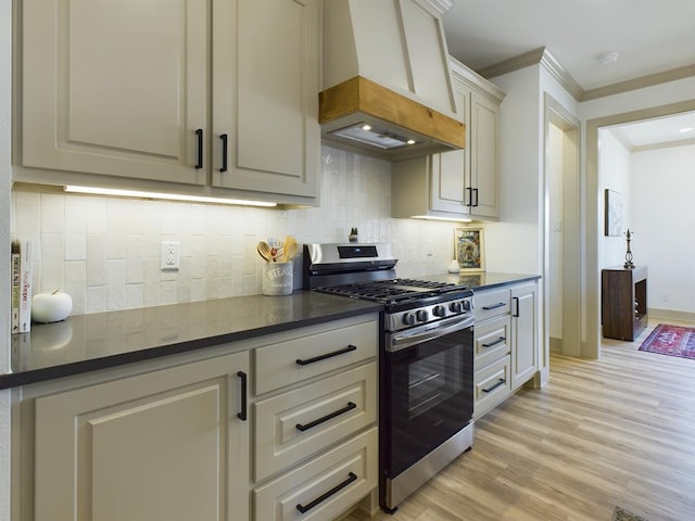 3608 Clearview Dr, San Angelo, TX 76904 - kitchen featuring stainless steel range with gas cooktop, premium range hood, dark countertops, ornamental molding, and tasteful backsplash
