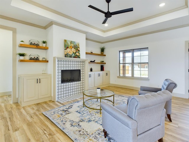 3608 Clearview Dr, San Angelo, TX 76904 - living room with a tray ceiling, ceiling fan, ornamental molding, light wood-style floors, and a fireplace