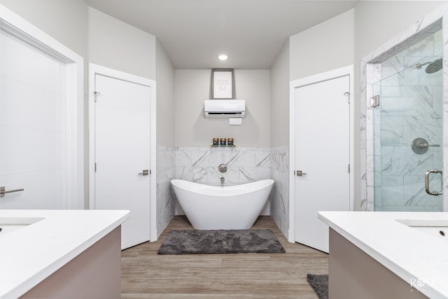 4992 Silver Creek Pass, San Angelo, TX 76904 - full bath featuring vanity, tile walls, a stall shower, a freestanding bath, and wood finished floors