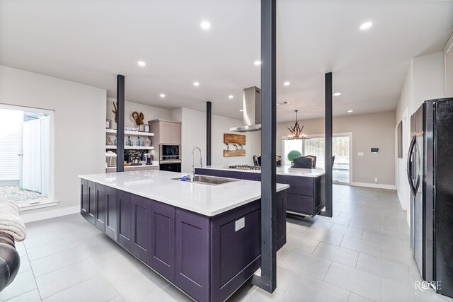 4992 Silver Creek Pass, San Angelo, TX 76904 - kitchen with black appliances, wall chimney exhaust hood, light countertops, a spacious island, and light tile patterned floors