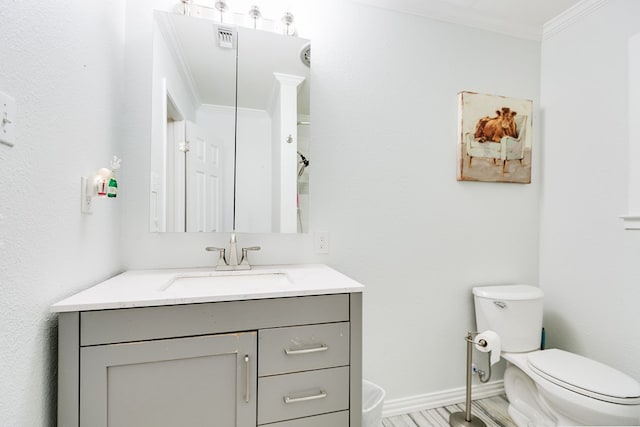 bathroom featuring ornamental molding, toilet, and vanity