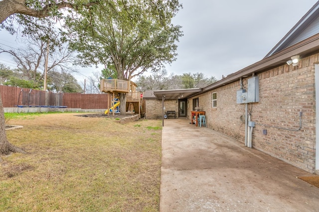 view of yard with a trampoline and a patio area