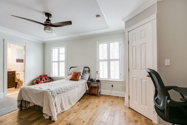 bedroom with multiple windows, ensuite bathroom, light wood-type flooring, and ceiling fan