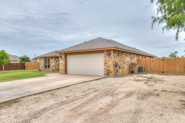 7805 Elk Run, San Angelo, TX 76901 - view of side of home featuring stone siding, an attached garage, driveway, and central AC