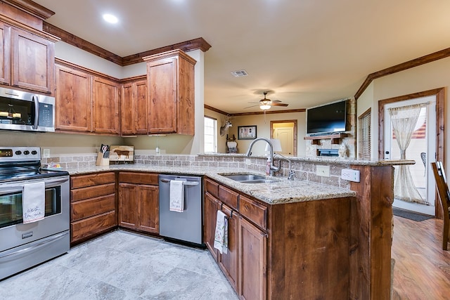 7805 Elk Run, San Angelo, TX 76901 - kitchen featuring stainless steel appliances, a sink, a ceiling fan, a peninsula, and ornamental molding