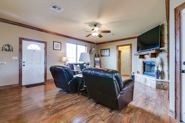 7805 Elk Run, San Angelo, TX 76901 - living room featuring a ceiling fan, wood finished floors, a stone fireplace, and crown molding