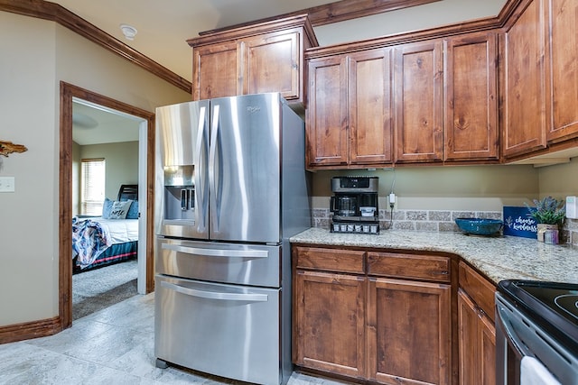 7805 Elk Run, San Angelo, TX 76901 - kitchen featuring stainless steel fridge, light stone counters, brown cabinets, and crown molding