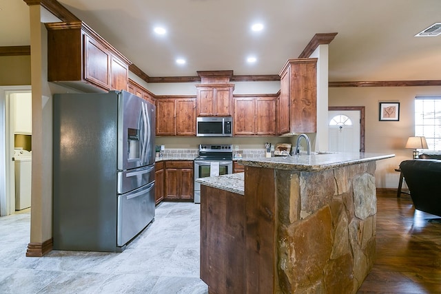7805 Elk Run, San Angelo, TX 76901 - kitchen with appliances with stainless steel finishes, a peninsula, crown molding, light stone counters, and baseboards