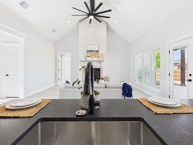 3725 Silver Spur Dr, San Angelo, TX 76904 - kitchen featuring a ceiling fan, open floor plan, a sink, dark countertops, and high vaulted ceiling