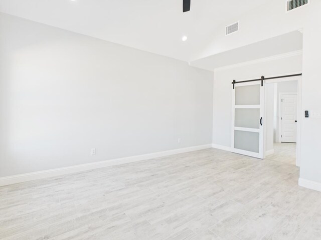 3725 Silver Spur Dr, San Angelo, TX 76904 - spare room with a barn door, vaulted ceiling, light wood-style flooring, baseboards, and recessed lighting