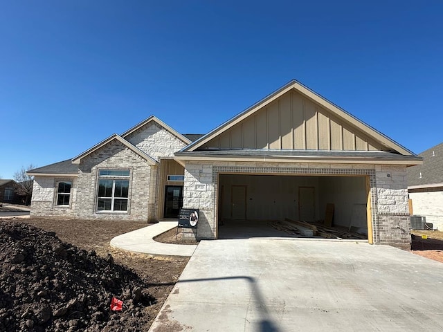 3725 Silver Spur Dr, San Angelo, TX 76904 - view of front of property with board and batten siding, a garage, concrete driveway, and stone siding
