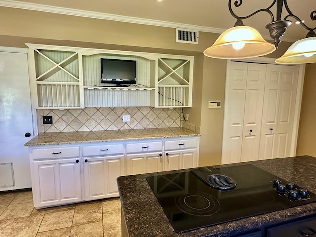 5202 Beverly Dr, San Angelo, TX 76904 - kitchen with black electric stovetop, backsplash, white cabinetry, dark stone counters, and crown molding
