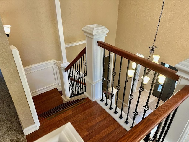 5202 Beverly Dr, San Angelo, TX 76904 - stairway featuring a textured wall, wood finished floors, and wainscoting