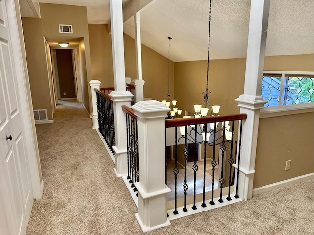 5202 Beverly Dr, San Angelo, TX 76904 - corridor with carpet flooring, vaulted ceiling, an upstairs landing, a chandelier, and decorative columns