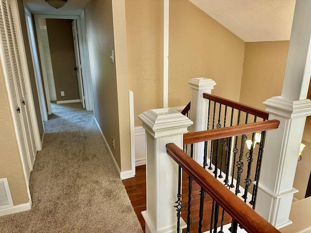 5202 Beverly Dr, San Angelo, TX 76904 - hallway with an upstairs landing, a textured wall, baseboards, and a textured ceiling