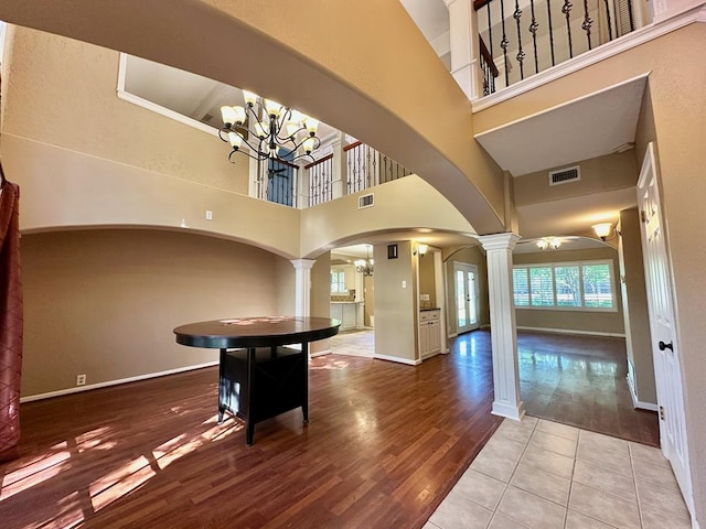 5202 Beverly Dr, San Angelo, TX 76904 - unfurnished dining area featuring ornate columns, arched walkways, a high ceiling, and wood finished floors