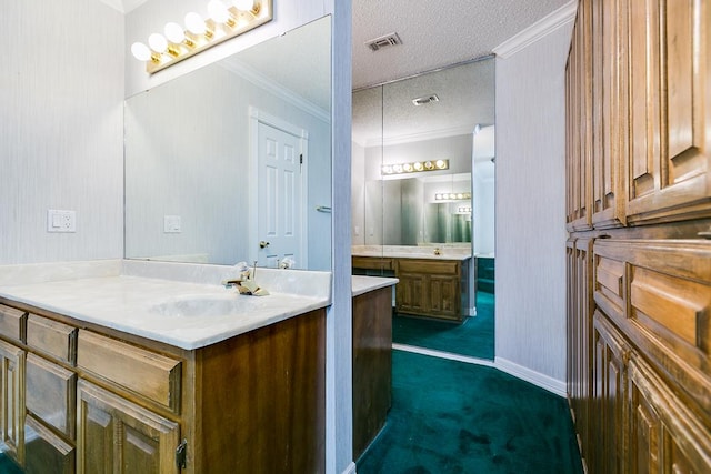  - bathroom featuring vanity, a textured ceiling, ornamental molding, and baseboards