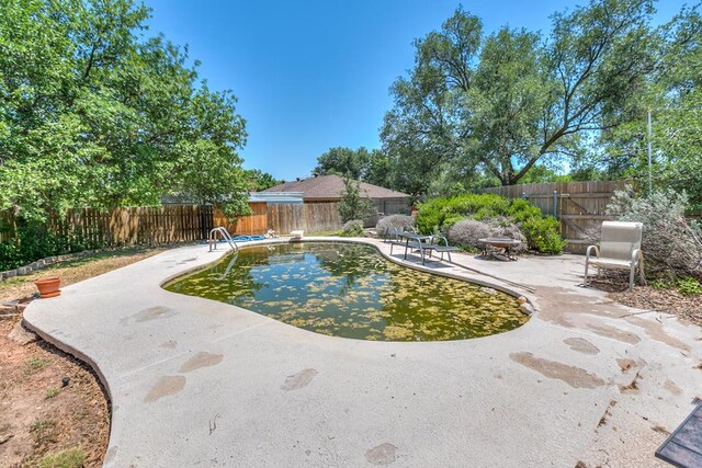  - view of pool with a patio area and a fenced backyard