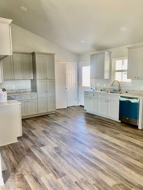 kitchen with sink, stainless steel dishwasher, white cabinets, and light hardwood / wood-style floors