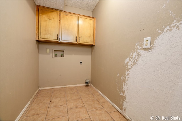 3317 Rockbrook Dr, San Angelo, TX 76904 - washroom featuring cabinet space, washer hookup, electric dryer hookup, light tile patterned flooring, and a textured ceiling