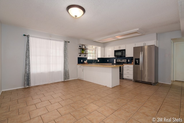 3317 Rockbrook Dr, San Angelo, TX 76904 - kitchen featuring appliances with stainless steel finishes, a textured ceiling, a peninsula, white cabinets, and open shelves