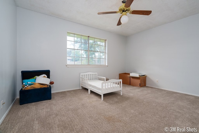 3317 Rockbrook Dr, San Angelo, TX 76904 - carpeted bedroom with a nursery area, a textured ceiling, and ceiling fan